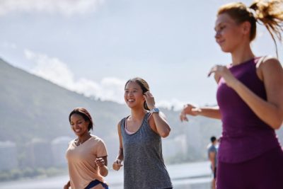 Three women jogging outdoors in an active, health-focused lifestyle, representing the shift toward non-toxic living and holistic wellness choices